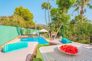 un tavolo con una ciotola di cocomeri sopra, accanto a una piscina di Finca Alqueria a Campanet