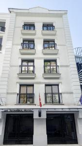 a tall white building with windows and balconies at UK HOTEL İSTANBUL in Istanbul