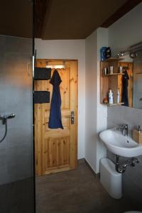 a bathroom with a wooden door and a sink at Pension und Falknerei an der alten Schmiede in Bernstadt +20 photos