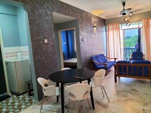 - un salon avec une table et des chaises noires dans l'établissement Glory beach seaview resort 2 bedroom, à Port Dickson