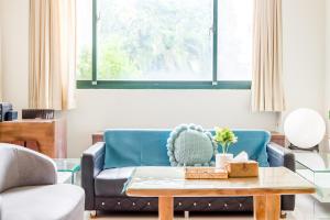 un salon avec un canapé bleu et une table basse dans l'établissement Travel Road WuWu, à Taïtung 45 autres photos