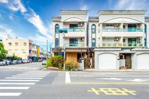 un grand bâtiment blanc dans une rue de la ville avec un passage piéton dans l'établissement Travel Road WuWu, à Taïtung