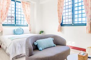 une chambre avec un lit avec une chaise et des fenêtres dans l'établissement Travel Road WuWu, à Taïtung