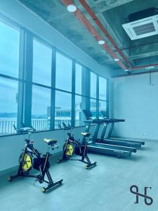 a gym with two exercise bikes in a room with windows at Homesuite' Home at Jesselton Quay in Kota Kinabalu