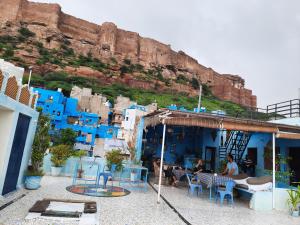 Kesar Heritage Boutique Home Stay في جودبور: مجموعة من الناس يجلسون خارج المبنى الأزرق +60 صورة