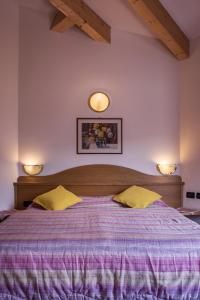 ein Schlafzimmer mit einem großen Bett mit zwei Leuchten an der Wand in der Unterkunft Hotel Sonne Sole in Vigo di Fassa