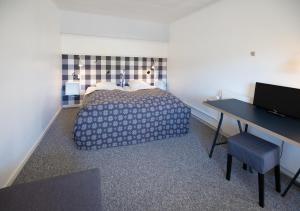 1 dormitorio con 1 cama y escritorio con escritorio en Tylstrup Kro og Motel, en Tylstrup