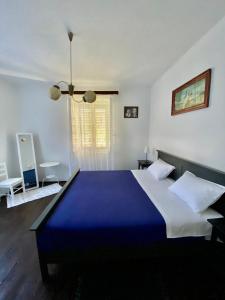 a bedroom with a large bed with a blue blanket at Family house Bacalja in Preko
