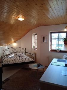 a bedroom with a bed and a table and a window at Vila Štefan Drevko in Poprad