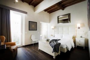 a bedroom with a white bed and a large window at Florence Art Apartments in Florence