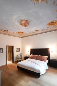 1 dormitorio con 1 cama y una pintura en el techo en Florence Art Apartments en Florencia