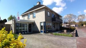 un edificio con una bandera a un lado. en Appartement Mijn Ouders Bed en Breakfast Emmeloord en Emmeloord