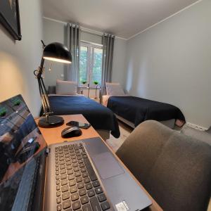 een woonkamer met een laptop op een bureau bij Apartament Vincent in Krapkowice