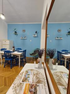 a room with tables and chairs and a mirror at La Casita Vendégház in Eger