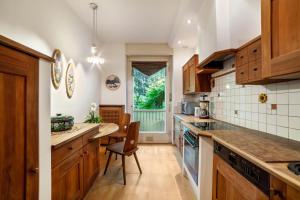 a kitchen with wooden cabinets and a table and a window at Villa Coris Ferienwohnung Magnolia in Merano