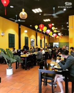 a group of people sitting at tables in a restaurant at Capsule Vinhomes Ocean Park in Hanoi