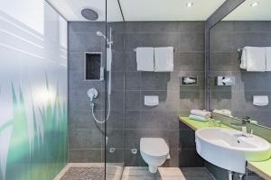 une salle de bain avec une douche, des toilettes et un lavabo dans l'établissement Garner Hotel Bremen City by IHG, à Brême 90 autres photos