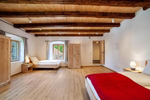 a bedroom with wooden ceilings and a red bed at Unterlanpacher Historic Refugium in Laces