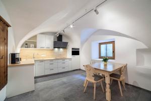 a kitchen with a table and chairs in a room at Unterlanpacher Historic Refugium in Laces