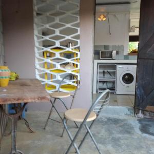 - une cuisine avec une table, des chaises et un casier à vin dans l'établissement Tikoté Chwit point 0, à Cayenne