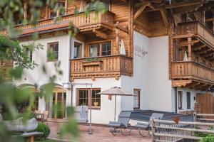 a building with a table and an umbrella in front of it at Wohlfühl Ferien-Heim Aparthotel 4 Sterne in Zell am Ziller