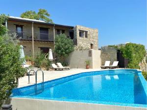 a swimming pool in front of a house at Eveleos Country House in Tochni