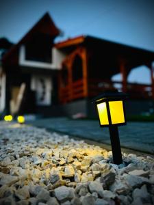 a yellow light on a pile of rocks in front of a house at Évi Vendégház Dunakanyar in Pilismarót