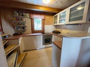 a kitchen with white appliances and a wooden ceiling at Velika Planina Koča Kekec in Stahovica