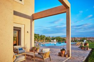 a patio with a table and chairs and a pool at Marrakech Villa Dar Belkiss in Tameslouht