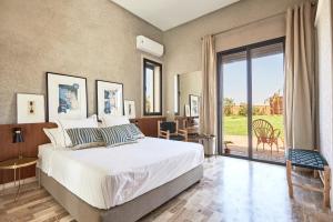 a bedroom with a bed and a large window at Marrakech Villa Dar Belkiss in Tameslouht +100 photos