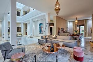 a living room with a couch and chairs and tables at Marrakech Villa Dar Belkiss in Tameslouht