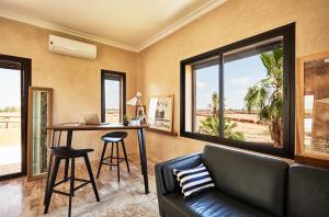 a living room with a couch and a table with a laptop at Marrakech Villa Dar Belkiss in Tameslouht