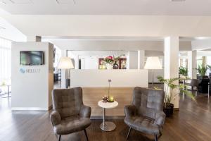 a lobby with two chairs and a table at Select Hotel Osnabrück in Osnabrück