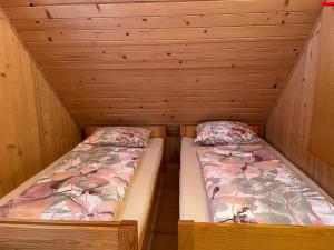 2 letti in una cabina con pareti in legno di Velika Planina Koča Kekec a Stahovica