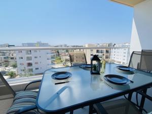 a table on a balcony with a view of a city at Silver Line 1-Bedroom Apartment in Larnaca in Larnaca