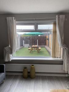 een raam met een picknicktafel in de achtertuin bij Bv Luxury Spacious 3 Bedroom House At Isaac Close in Manchester