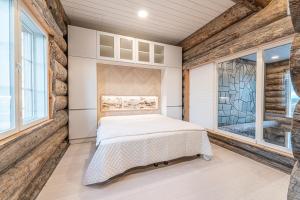 a bedroom with a bed and a stone wall at Fort Aurora in Levi
