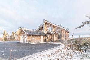 a log cabin with a driveway in front of it at Fort Aurora in Levi