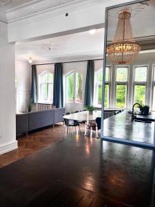 uma ampla sala de estar com uma mesa e um lustre em Villa Apartment near City Centre em Bronshoj