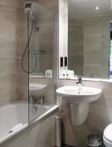 a bathroom with a sink and a shower and a toilet at Old Manor Hotel in Lundin Links