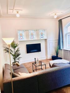 ein Wohnzimmer mit einem Sofa und einem Flachbild-TV in der Unterkunft Villa Apartment near City Centre in Bronshoj