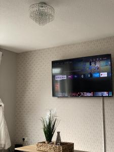 a flat screen tv hanging on a wall at Bv Luxury Spacious 3 Bedroom House At Isaac Close in Manchester