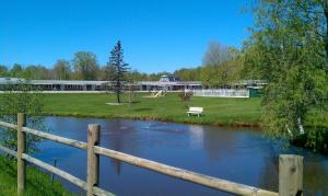 a wooden fence next to a river with a building at Middleton Motel & Suites in Middleton
