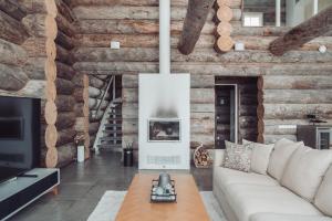 uma sala de estar com um sofá branco e paredes de madeira em Fort Aurora em Levi