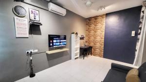 a living room with a tv on a wall at Eisya Guest House With Pool in Arau