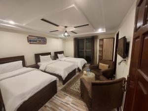 a hotel room with two beds and a tv at birmingam palace kalam in Kalām