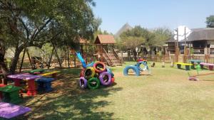 a playground with colorful play equipment in a park at Gabbata Lodge in Leeuwfontein