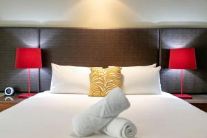 En eller flere senger på et rom på Darwin Harbourside Escape - Two Adjacent King Suites