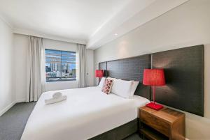 En eller flere senger på et rom på Darwin Harbourside Escape - Two Adjacent King Suites