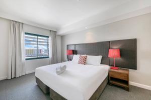 En eller flere senger på et rom på Darwin Harbourside Escape - Two Adjacent King Suites